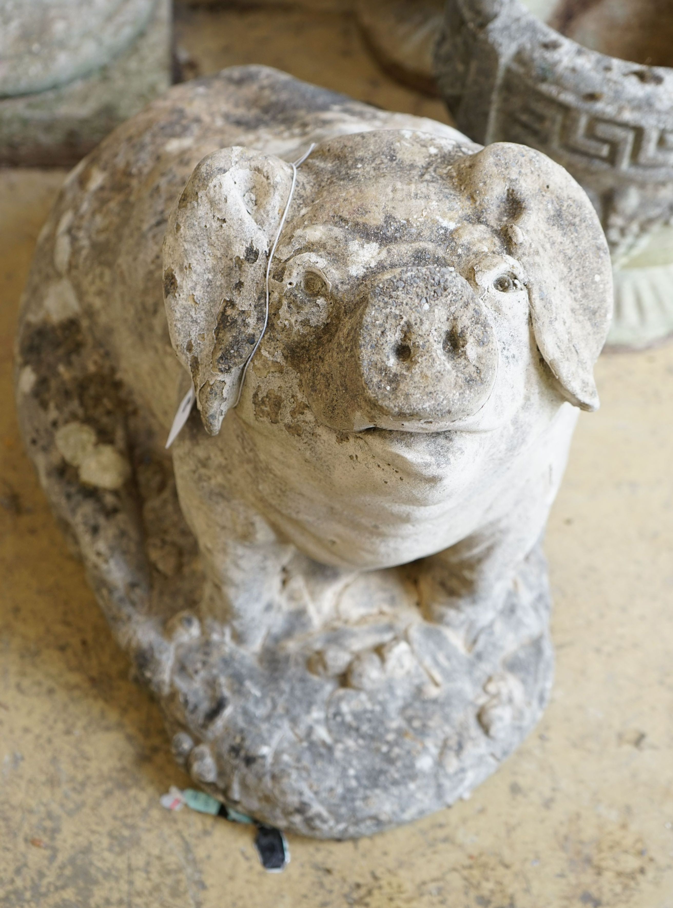 A reconstituted stone seated pig garden ornament, height 38cm